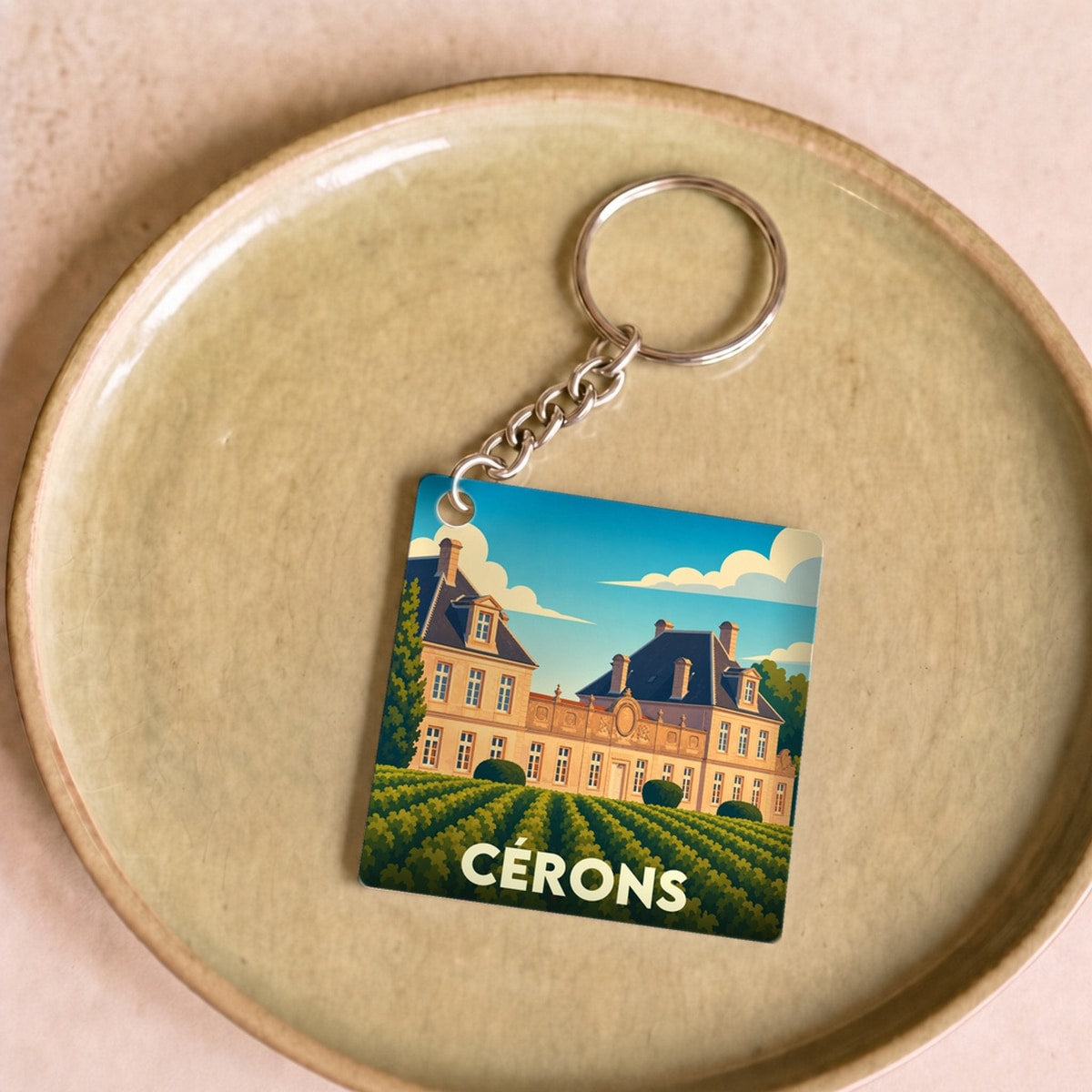 Porte-clés souvenir de la ville de Cérons avec une illustration stylisée d'un château et de ses vignes.