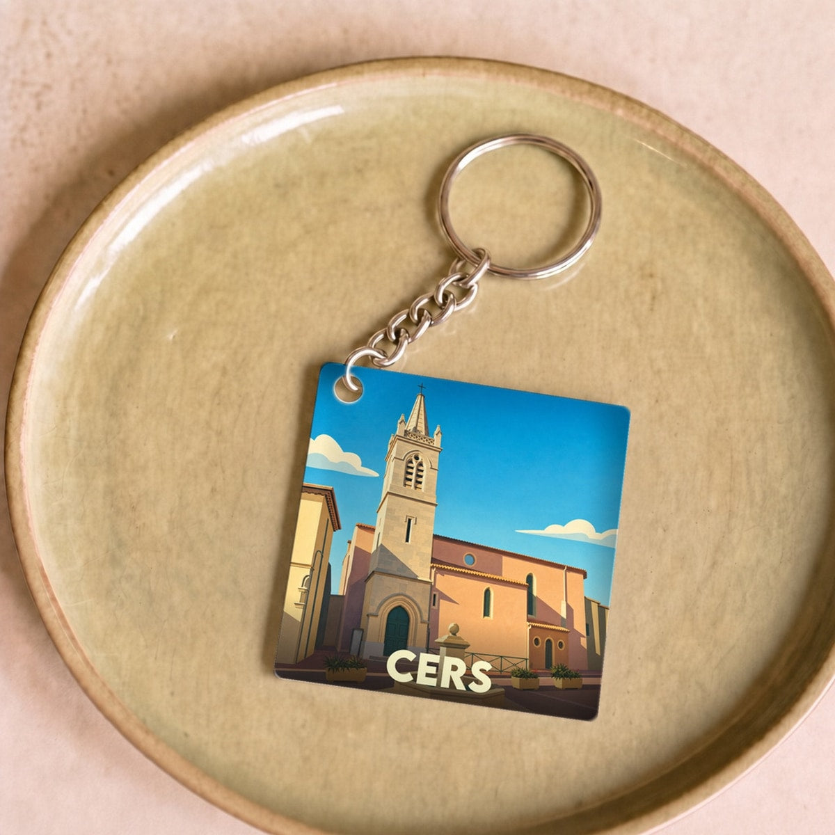 Porte-clés souvenir de la ville de Cers avec une illustration stylisée de son église.
