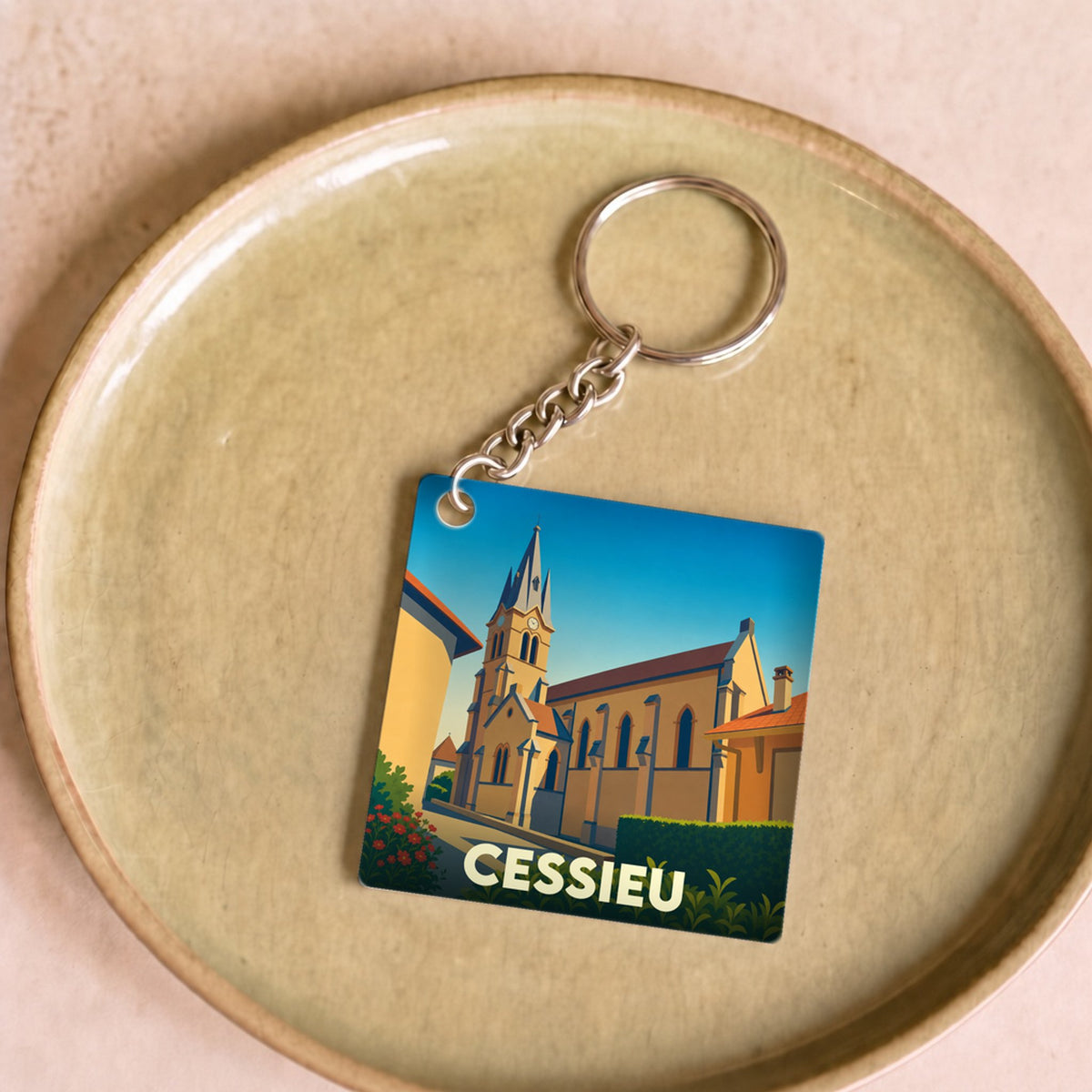 Porte-clés souvenir de la ville de Cessieu avec une illustration stylisée de son église.