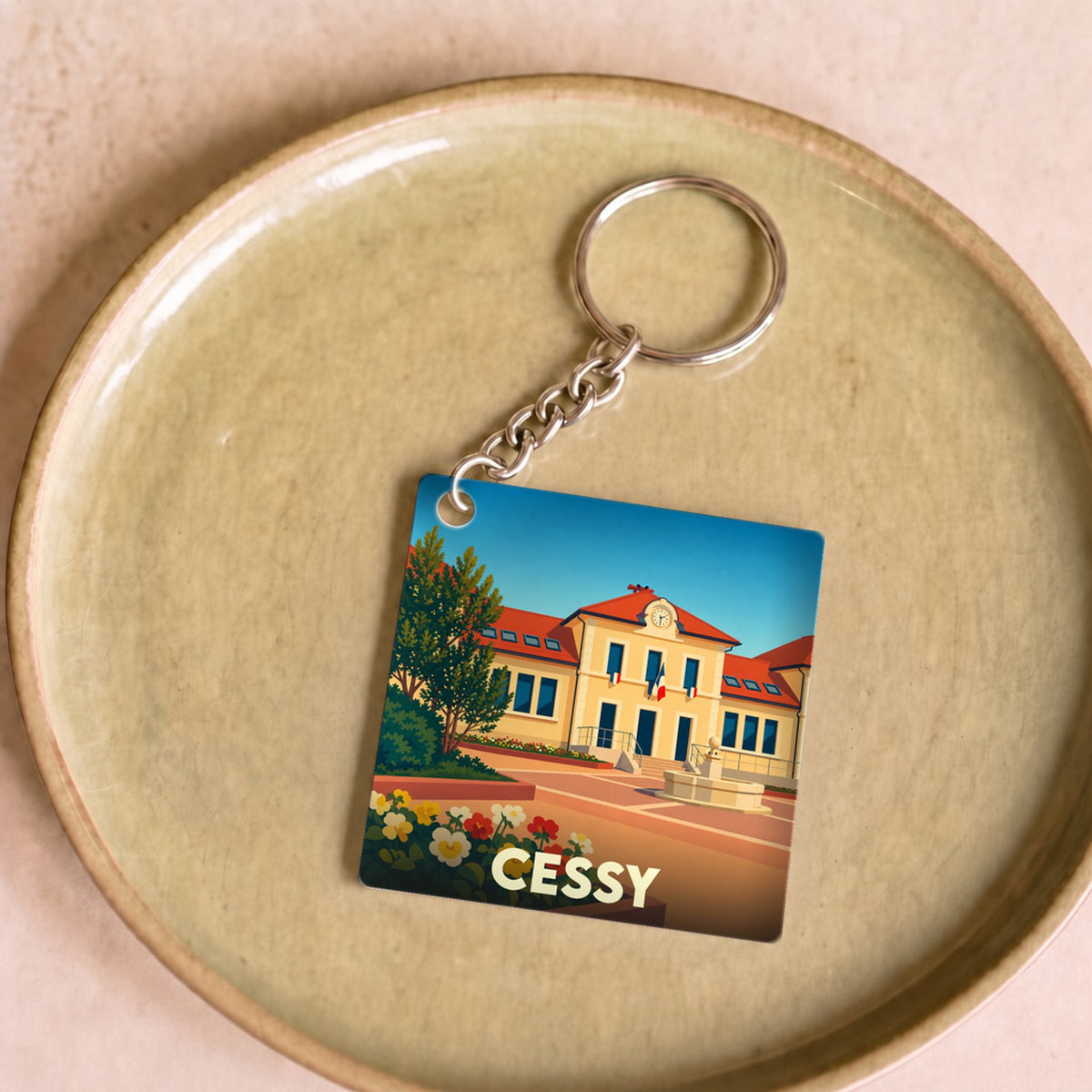 Porte-clés souvenir de la ville de Cessy avec une illustration stylisée.