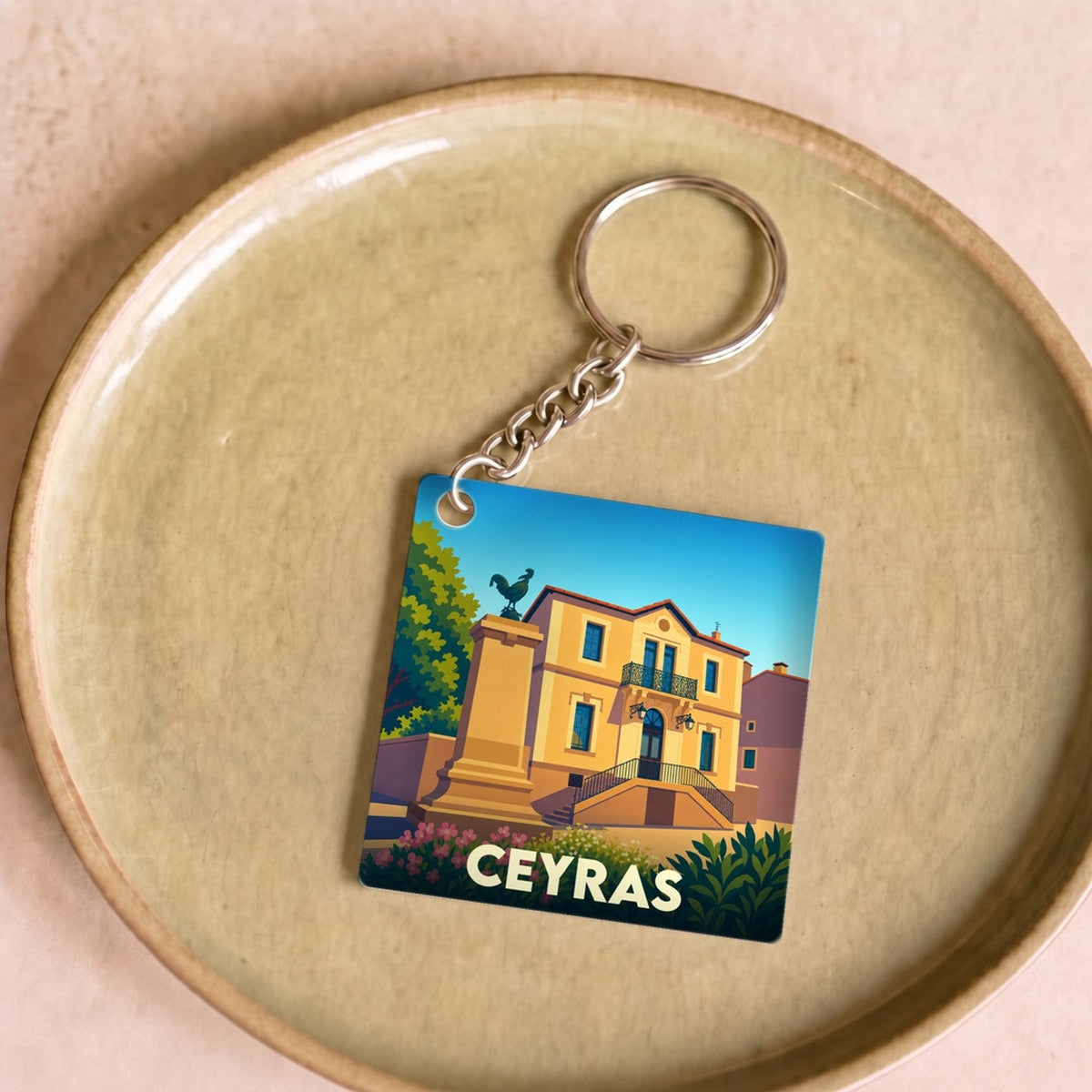 Porte-clés souvenir de la ville de Ceyras avec une illustration stylisée.