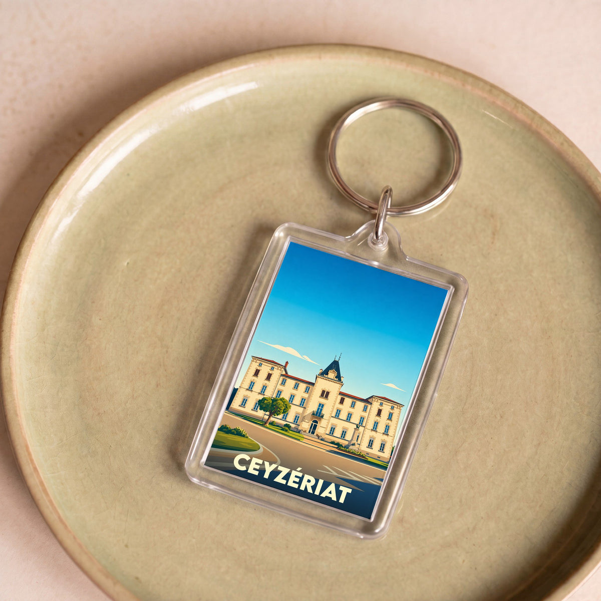 Porte-clés souvenir de la ville de Ceyzériat avec une illustration stylisée d'un bâtiment historique.