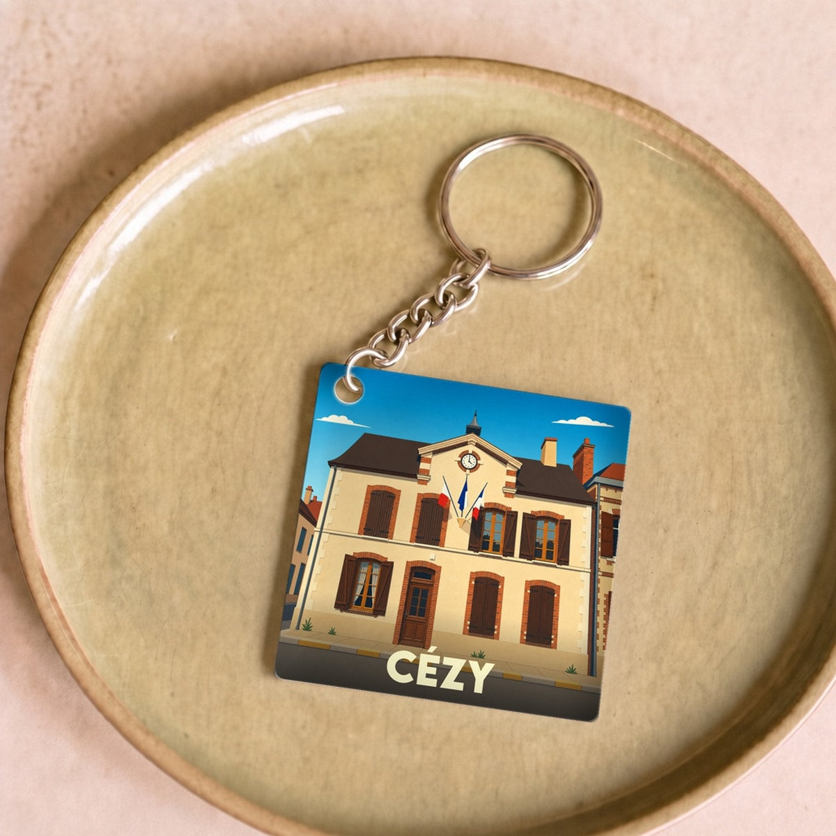 Porte-clés souvenir de la ville de Cézy avec une illustration stylisée de sa mairie.