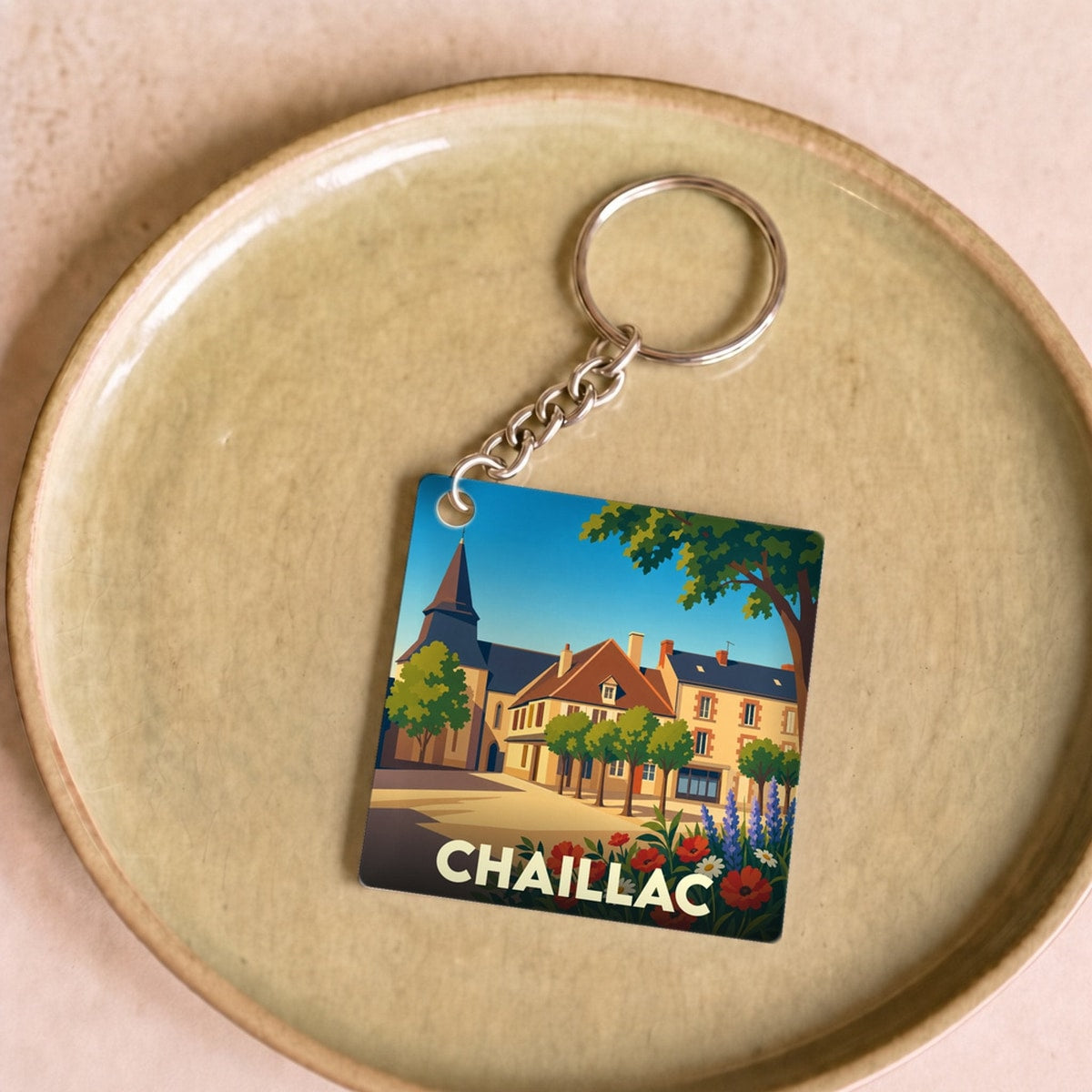 Porte-clés souvenir de la ville de Chaillac avec une illustration stylisée et colorée du village.