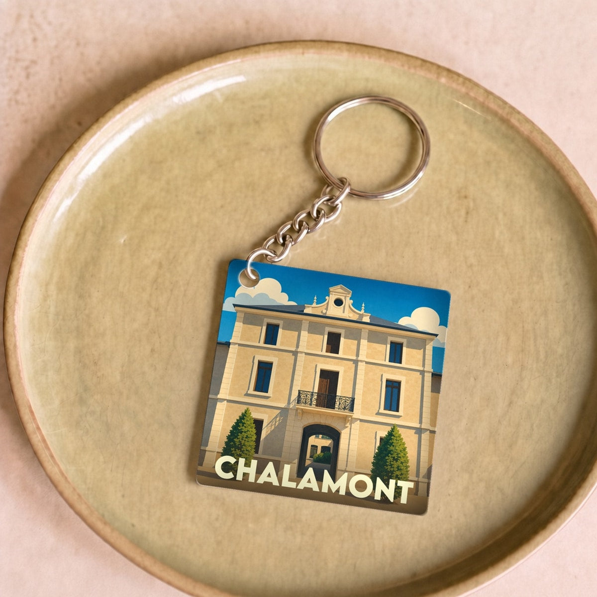 Porte-clés souvenir de la ville de Chalamont avec une illustration stylisée.