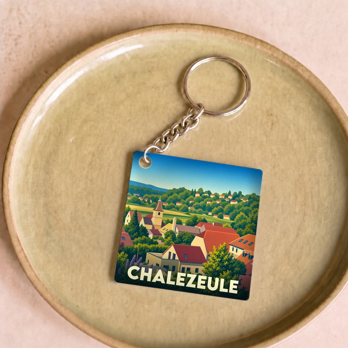 Porte-clés souvenir de la ville de Chalezeule avec une illustration stylisée.