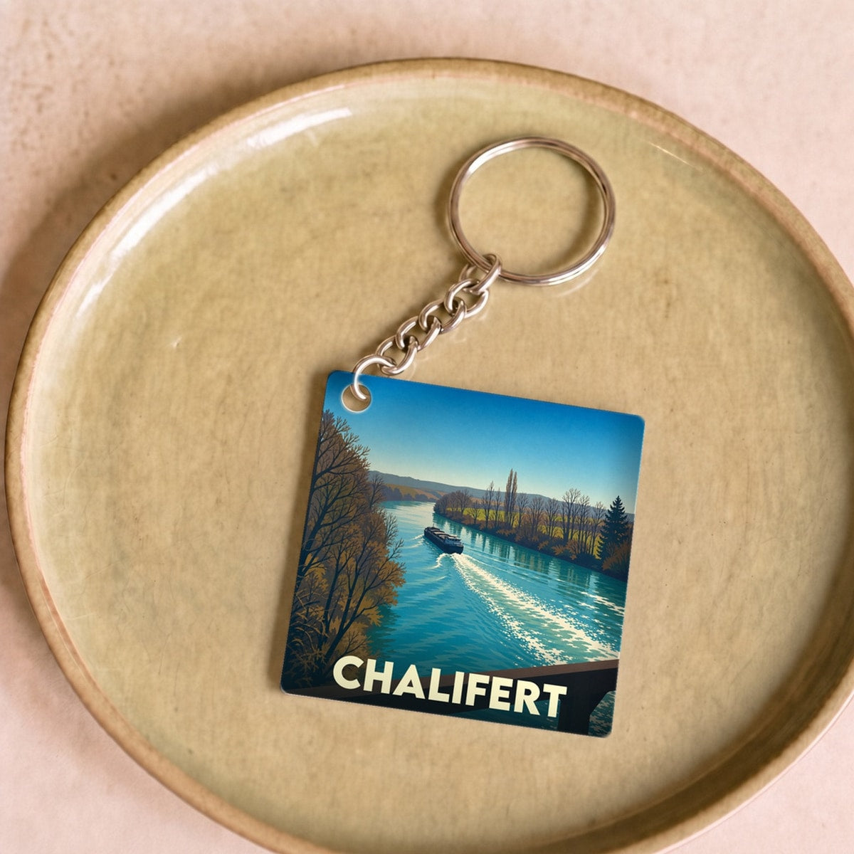 Porte-clés souvenir de la ville de Chalifert avec une illustration stylisée d'un bateau sur la Marne.