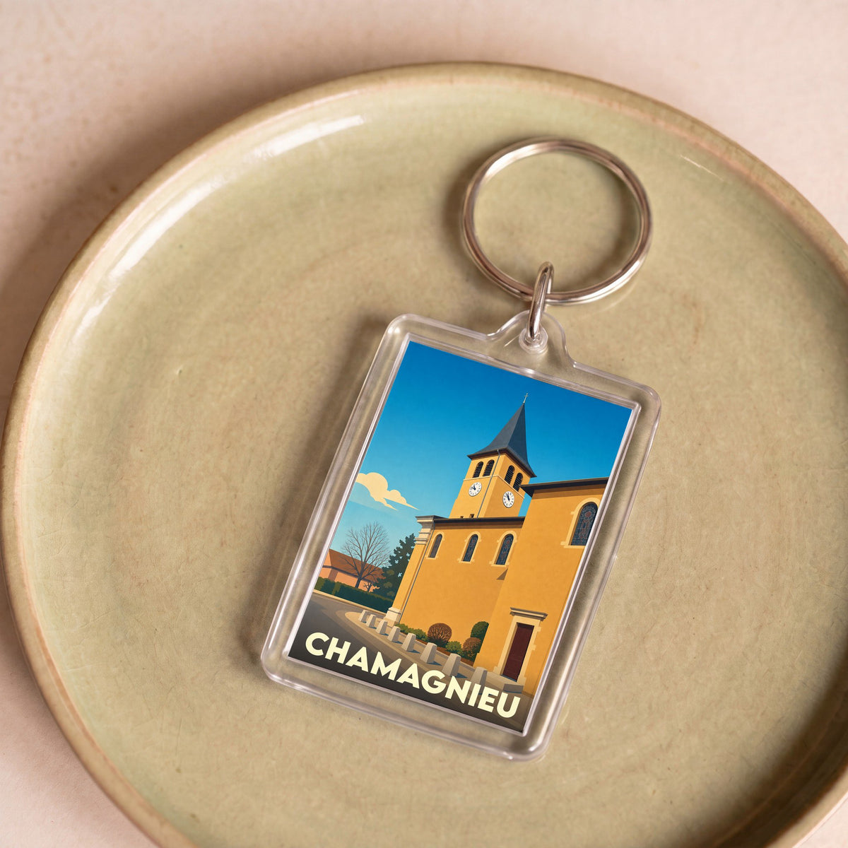Porte-clés souvenir de la ville de Chamagnieu avec une illustration stylisée de son église.