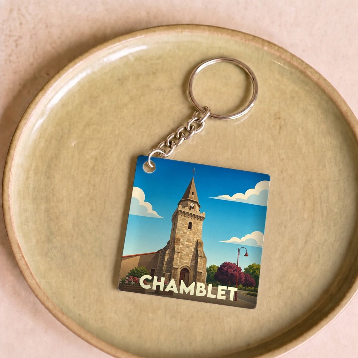 Porte-clés souvenir de la ville de Chamblet avec une illustration stylisée de son église.