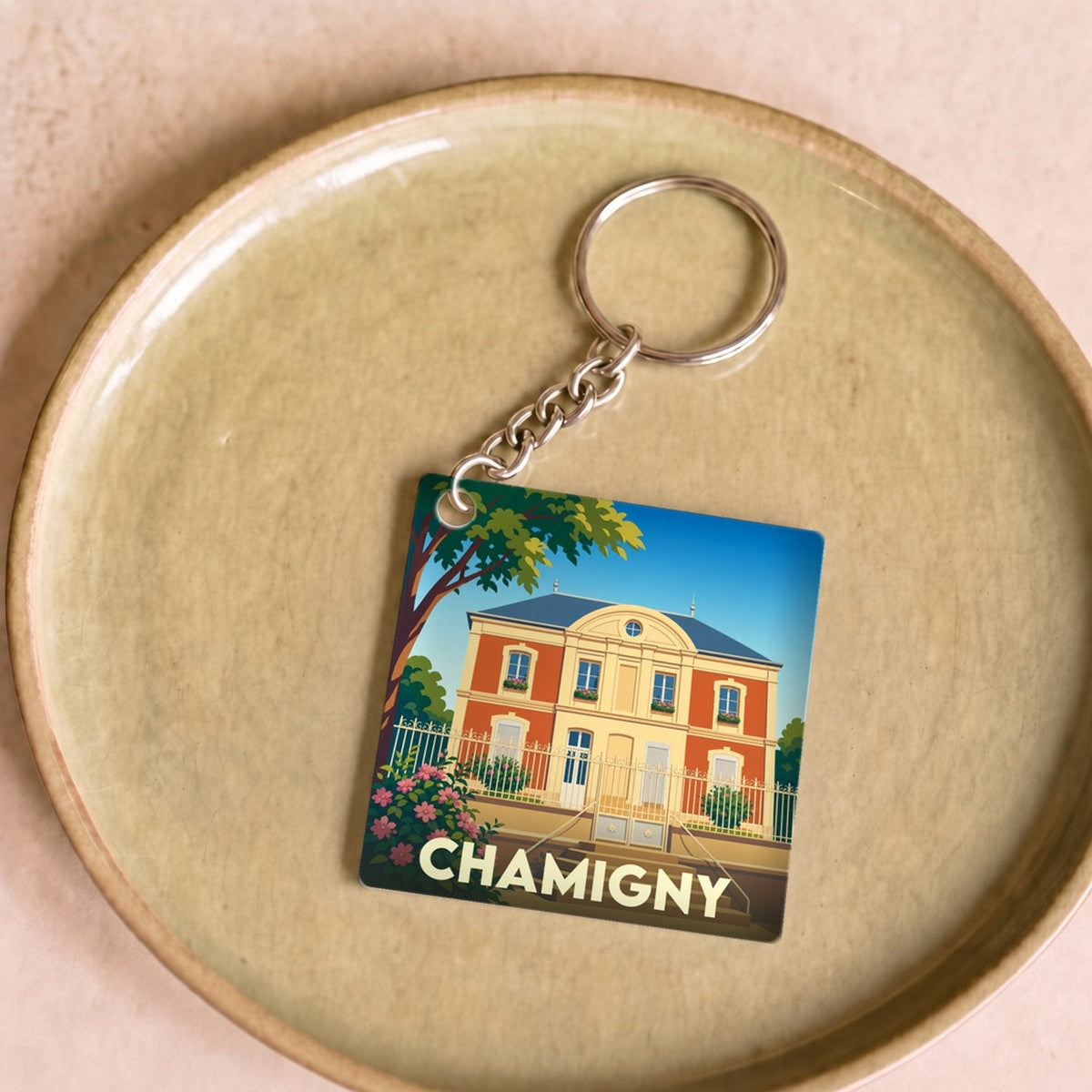 Porte-clés souvenir de la ville de Chamigny avec une illustration stylisée d'une demeure bourgeoise.