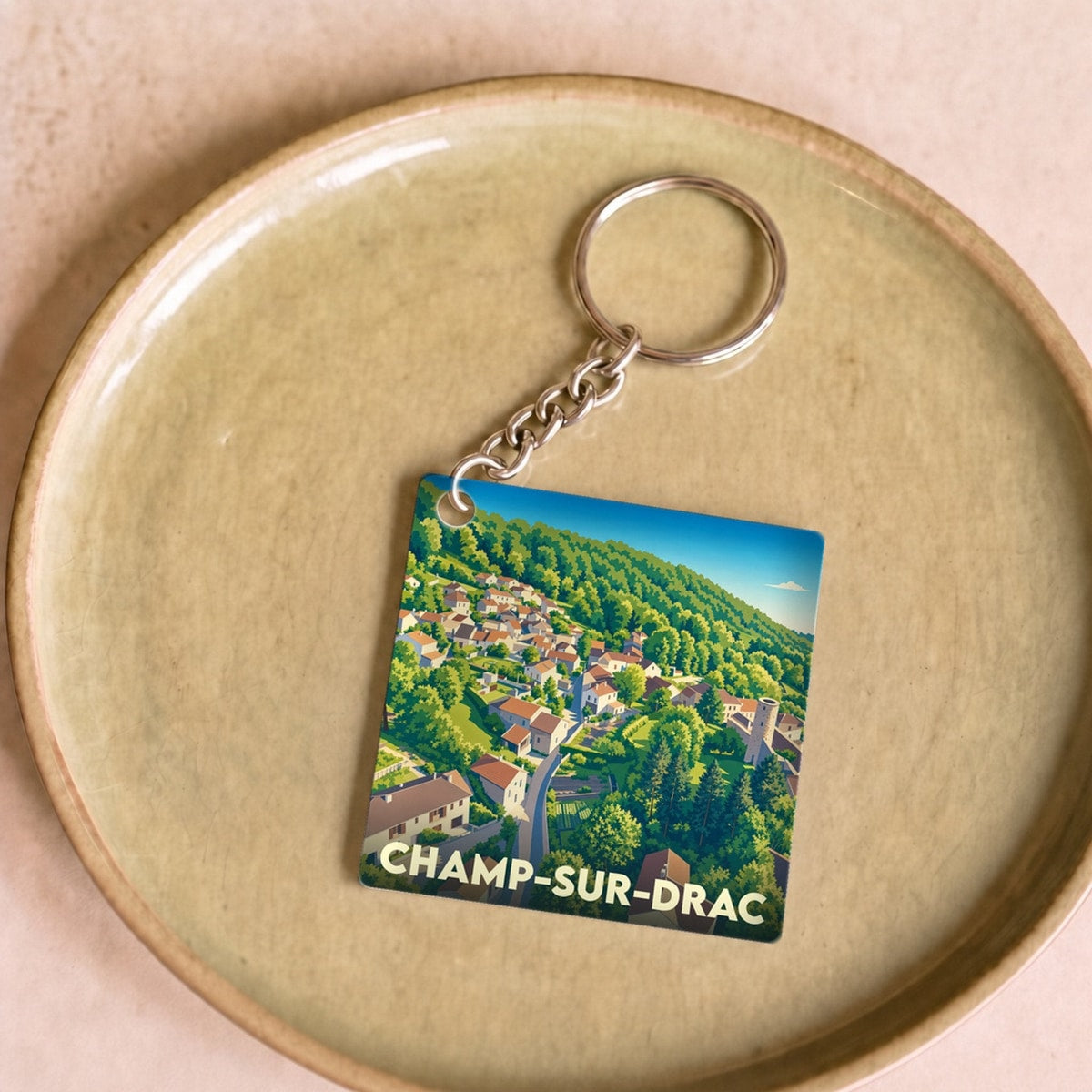 Porte-clés souvenir de la ville de Champ-sur-Drac avec une illustration stylisée.