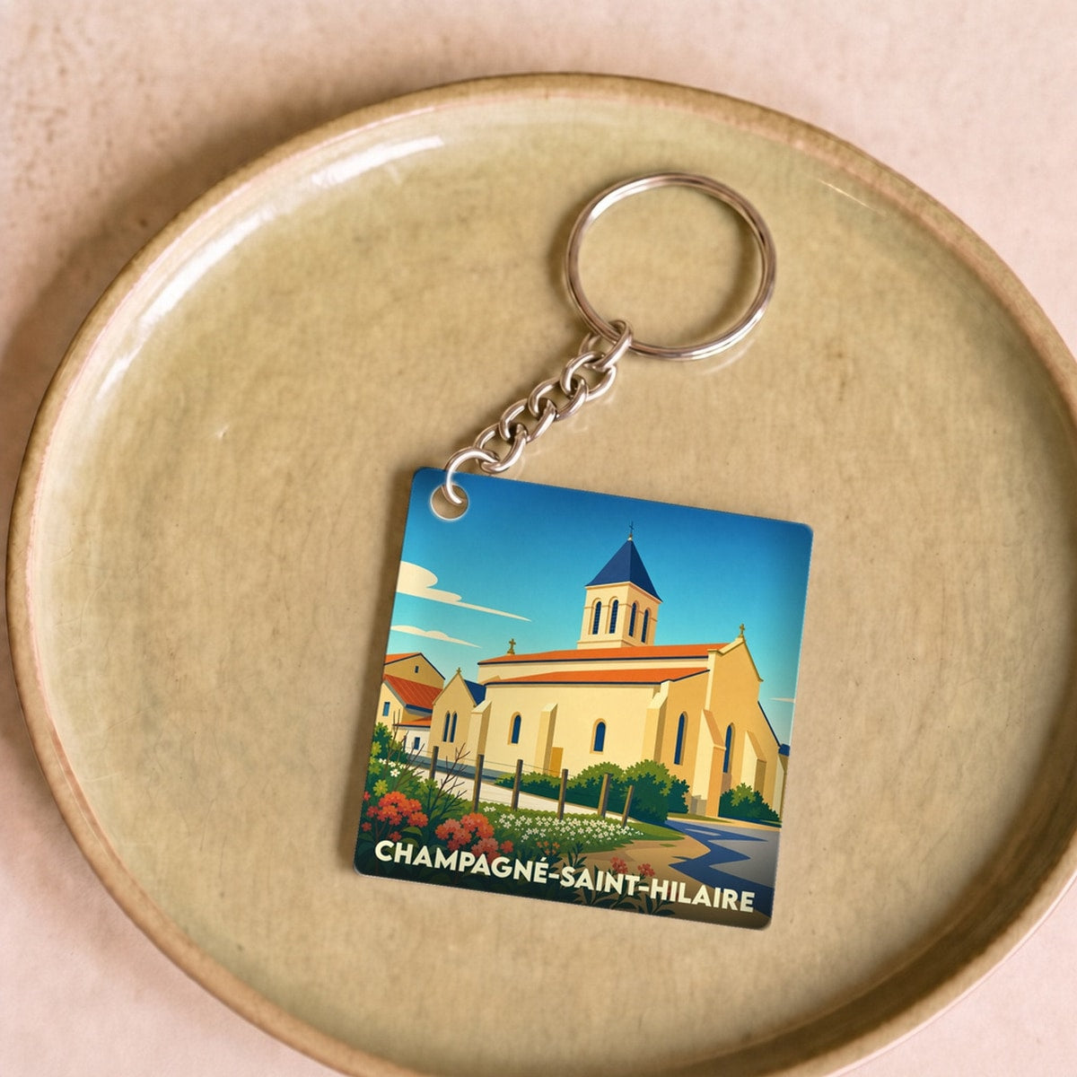 Porte-clés souvenir de la ville de Champagné-Saint-Hilaire avec une illustration stylisée de son église.
