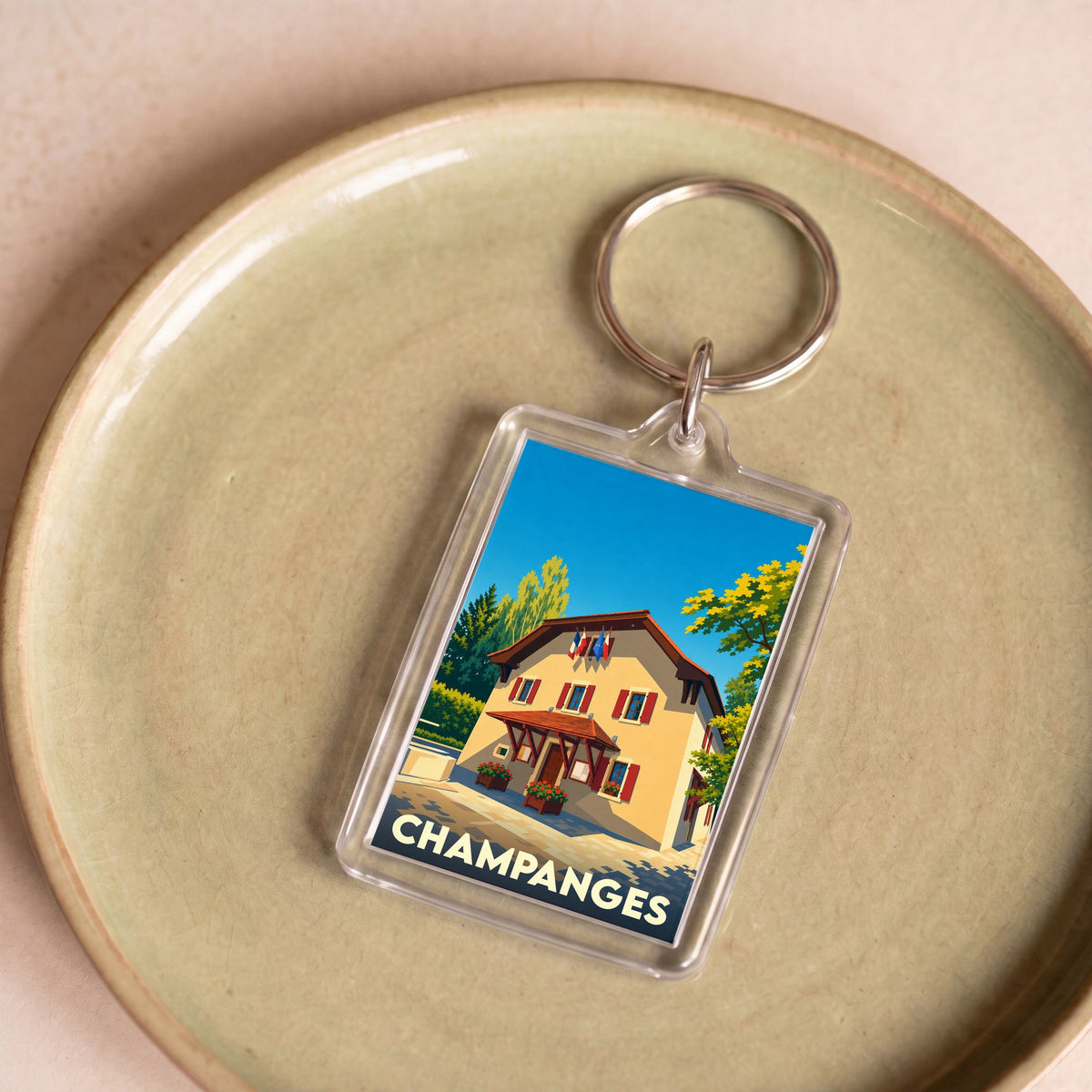 Porte-clés souvenir de la ville de Champanges avec une illustration stylisée de sa mairie.