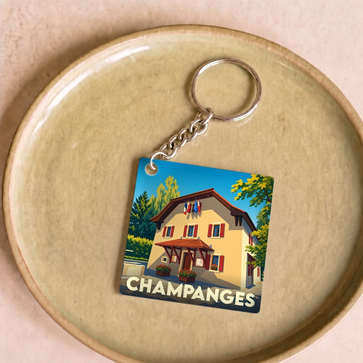 Porte-clés souvenir de la ville de Champanges avec une illustration stylisée de sa mairie.