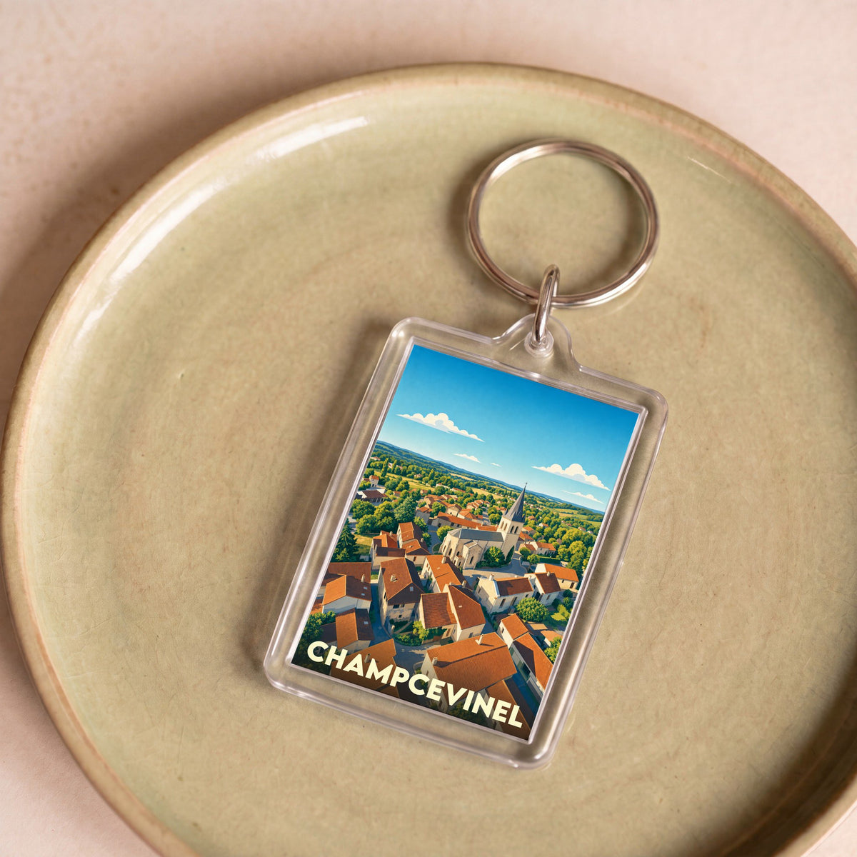 Porte-clés souvenir de la ville de Champcevinel avec une illustration stylisée.