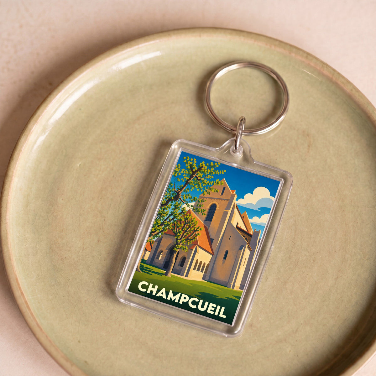 Porte-clés souvenir de la ville de Champcueil avec une illustration stylisée de son église.