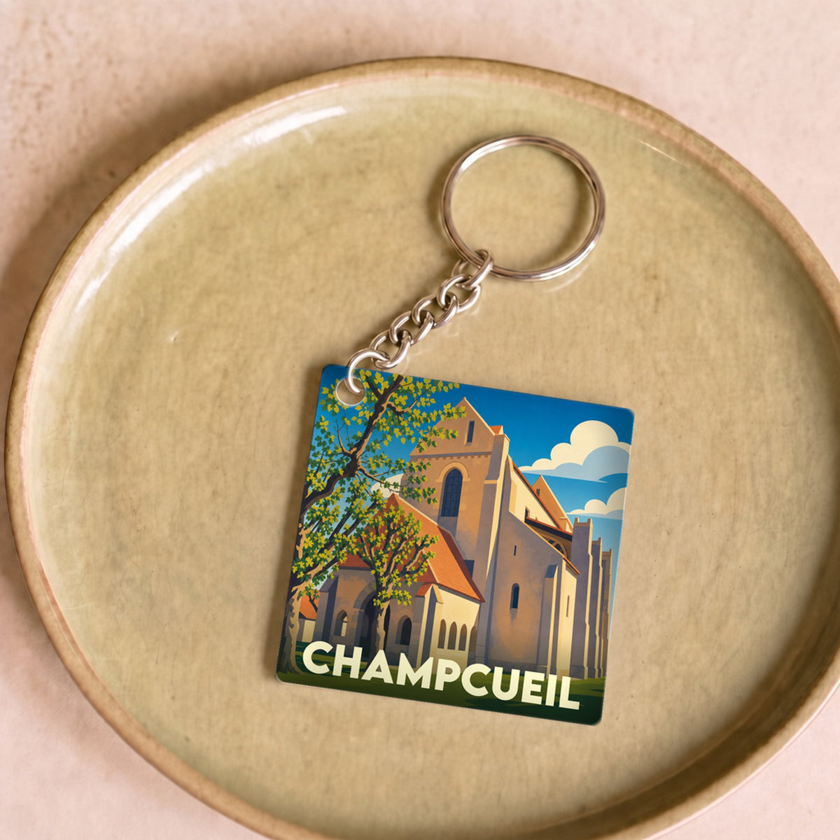 Porte-clés souvenir de la ville de Champcueil avec une illustration stylisée de son église.