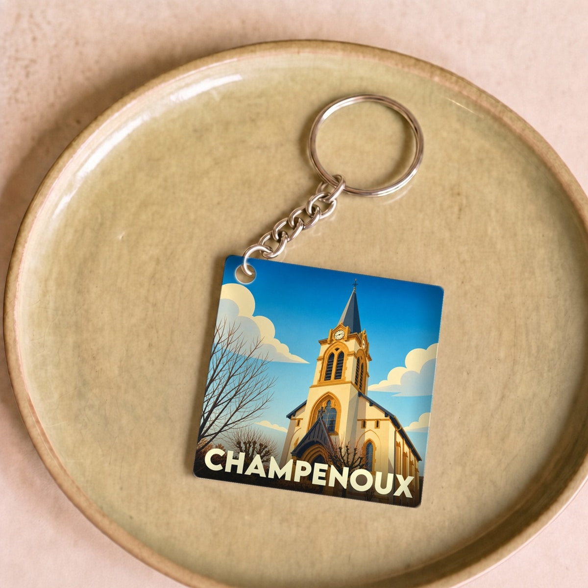 Porte-clés souvenir de la ville de Champenoux avec une illustration stylisée d'église.