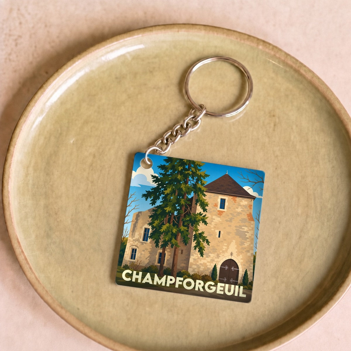Porte-clés souvenir de la ville de Champforgeuil avec une illustration stylisée de son patrimoine.
