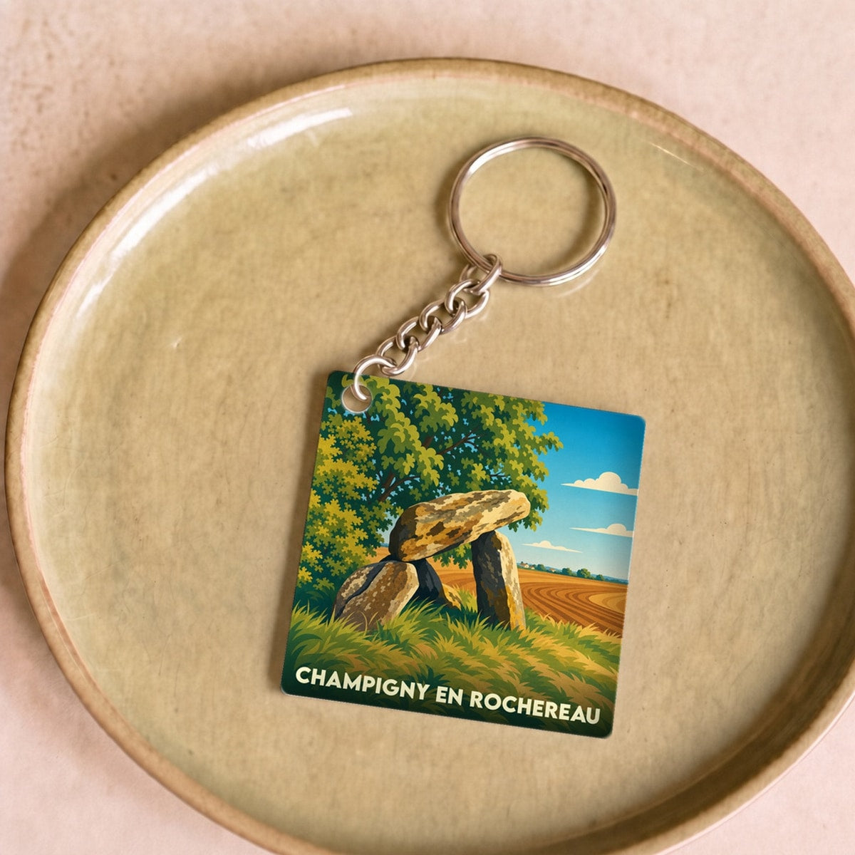 Porte-clés souvenir de la ville de Champigny en Rochereau avec une illustration stylisée d'un dolmen.
