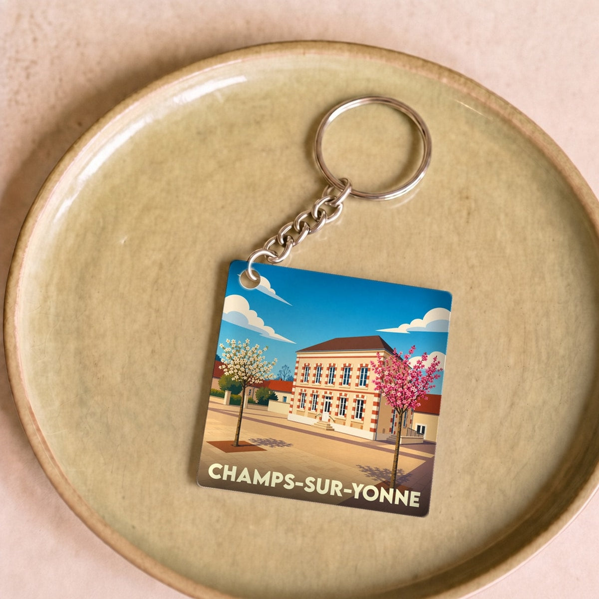 Porte-clés souvenir de la ville de Champs-sur-Yonne avec une illustration stylisée de sa mairie.