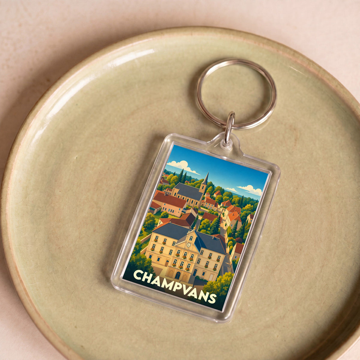 Porte-clés souvenir de la ville de Champvans avec une illustration stylisée.