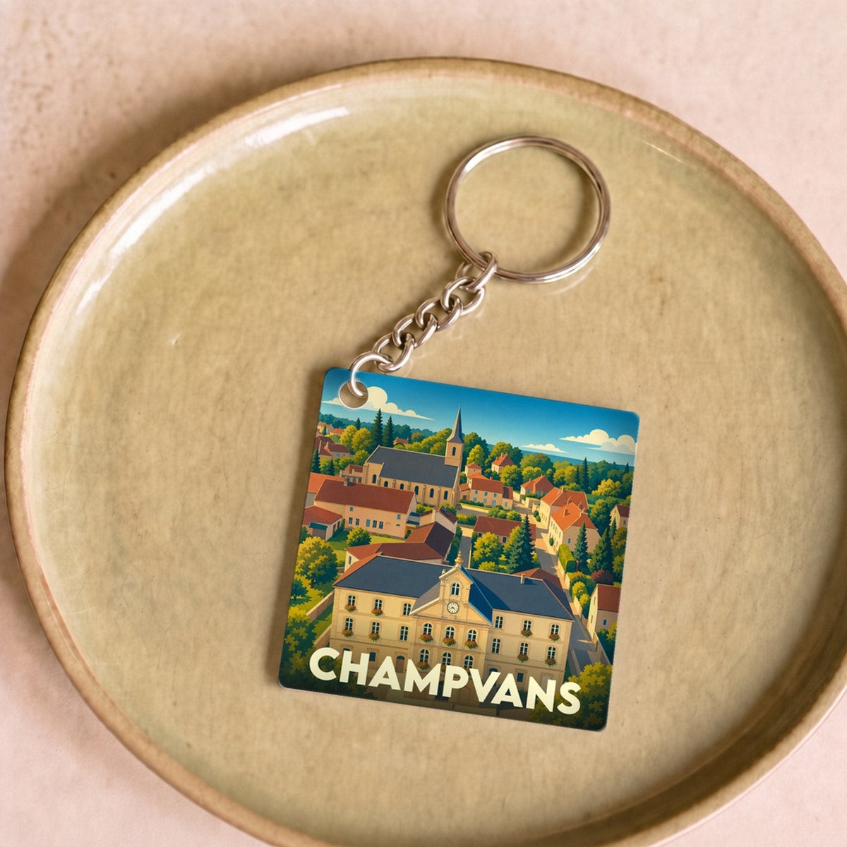 Porte-clés souvenir de la ville de Champvans avec une illustration stylisée.