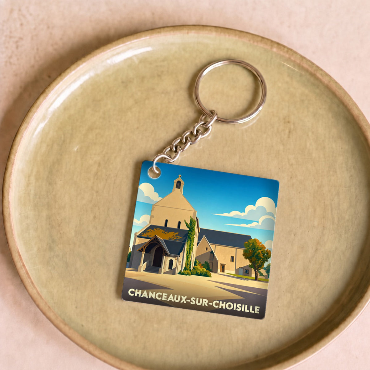 Porte-clés souvenir de la ville de Chanceaux-sur-Choisille avec une illustration stylisée de son église.