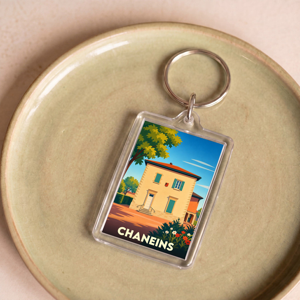 Porte-clés souvenir de la ville de Chaneins avec une illustration stylisée.