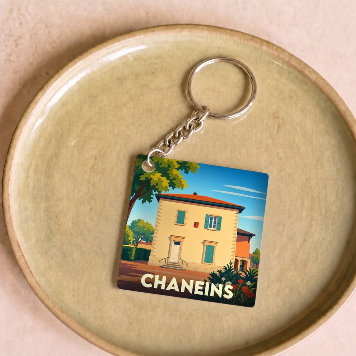 Porte-clés souvenir de la ville de Chaneins avec une illustration stylisée.