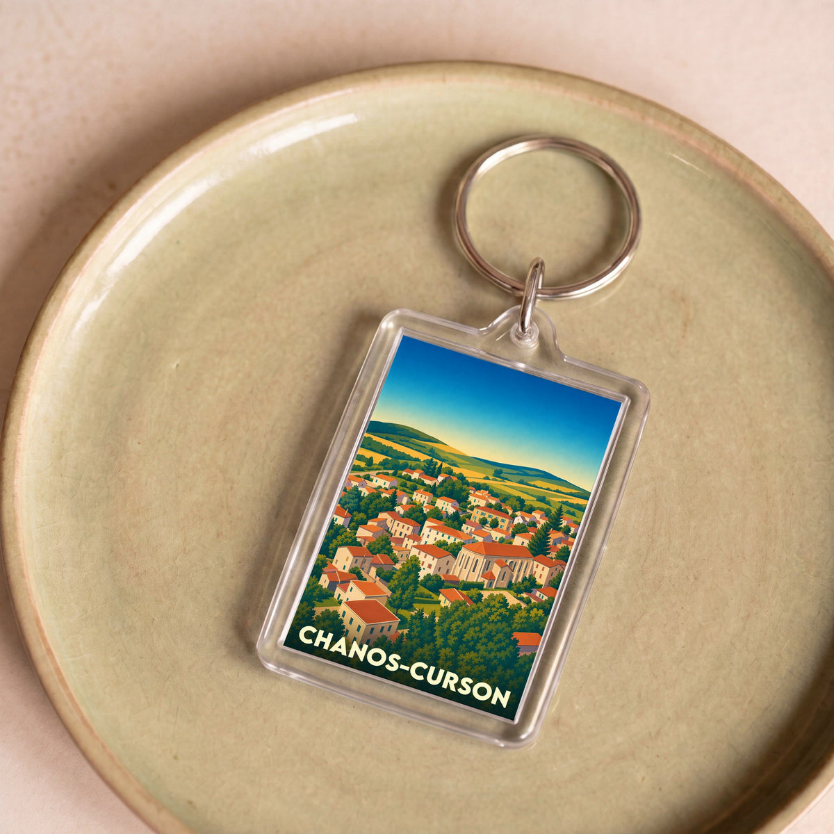 Porte-clés souvenir de la ville de Chanos-Curson avec une illustration stylisée.
