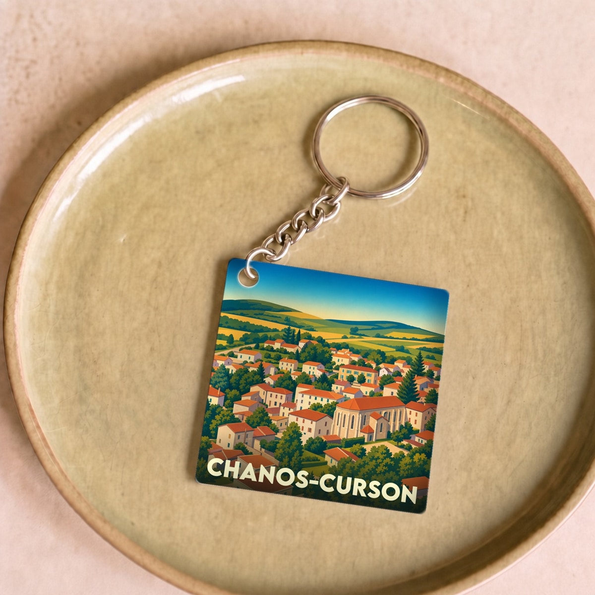 Porte-clés souvenir de la ville de Chanos-Curson avec une illustration stylisée.