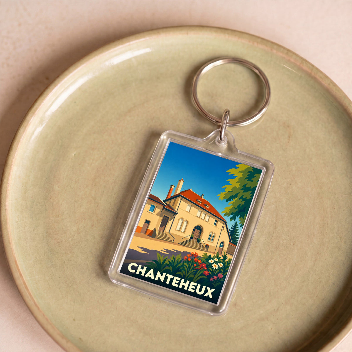 Porte-clés souvenir de la ville de Chanteheux avec une illustration stylisée d'un bâtiment historique.