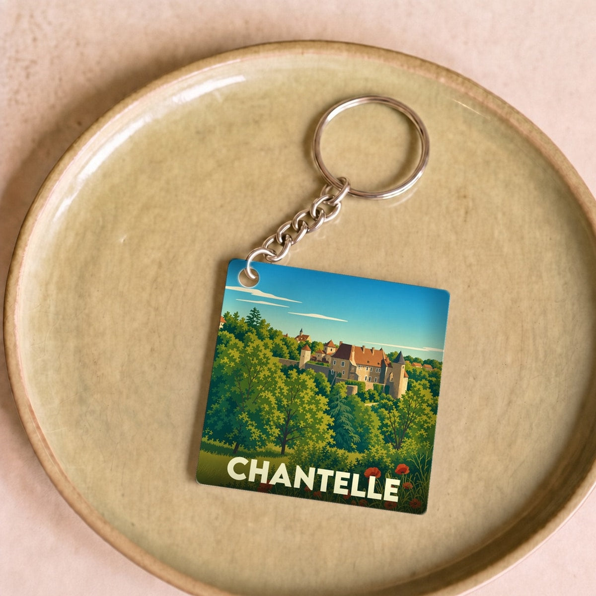Porte-clés souvenir de la ville de Chantelle avec une illustration stylisée de son patrimoine.