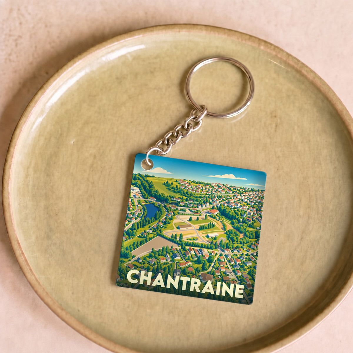 Porte-clés souvenir de la ville de Chantraine avec une illustration stylisée et colorée.