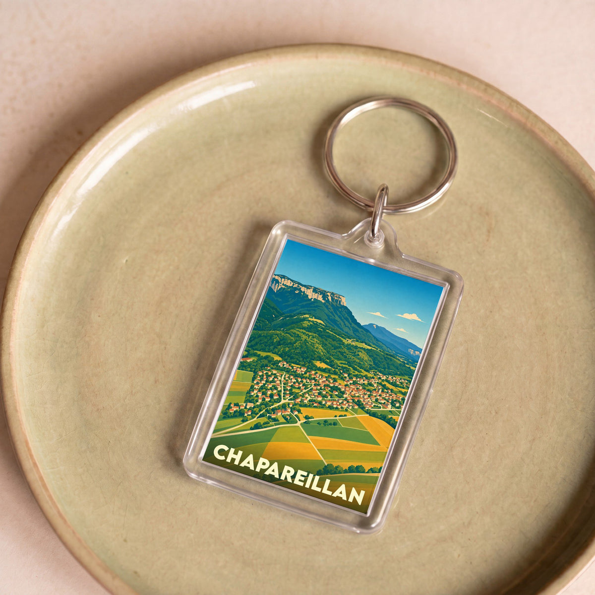 Porte-clés souvenir de la ville de Chapareillan avec une illustration stylisée de son paysage montagneux.