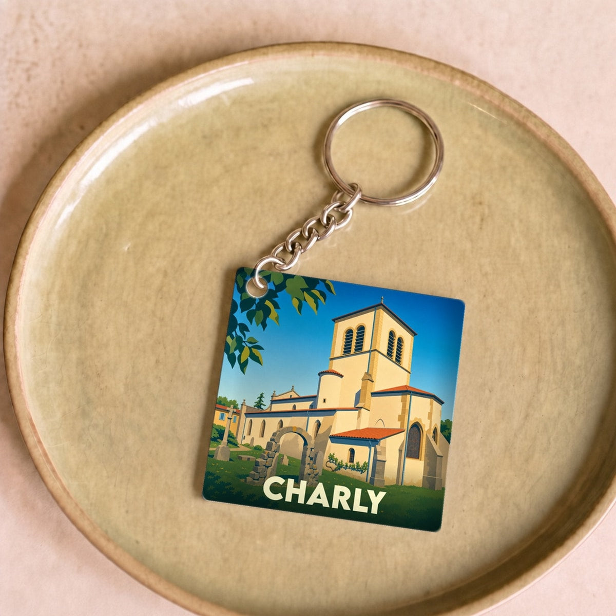 Porte-clés souvenir de la ville de Charly avec une illustration stylisée de son église.