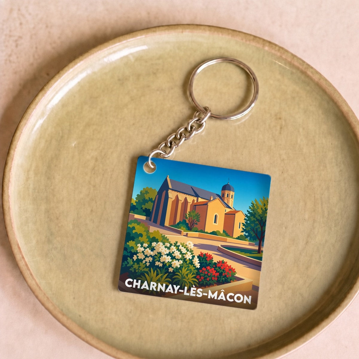 Porte-clés souvenir de Charnay-lès-Mâcon avec une illustration stylisée de son patrimoine.
