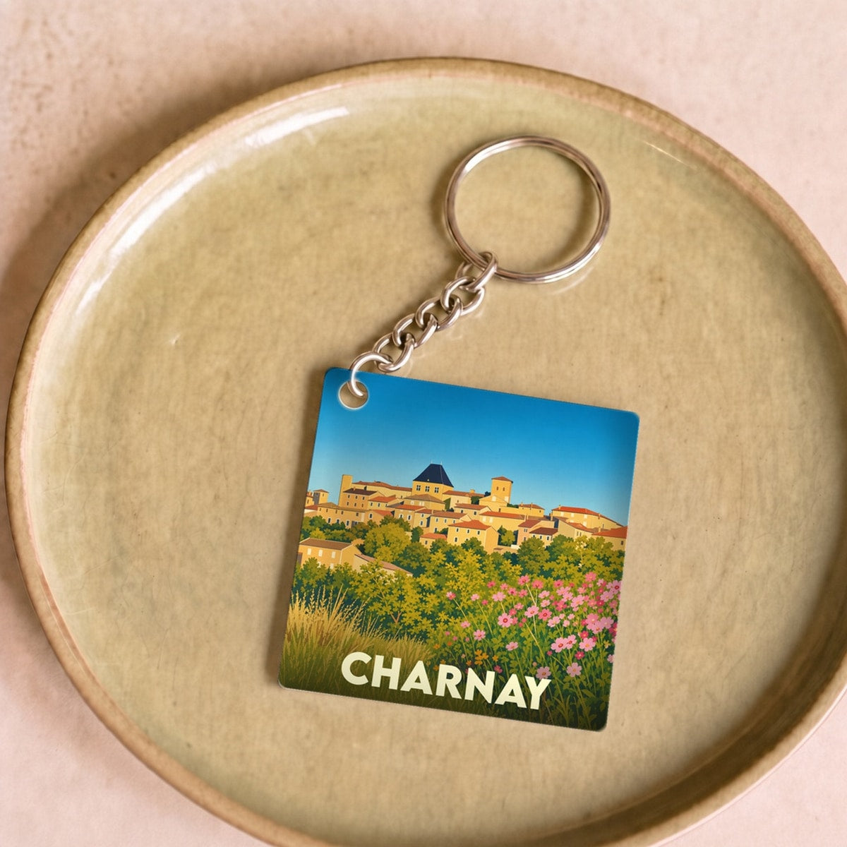 Porte-clés souvenir de la ville de Charnay avec une illustration stylisée.