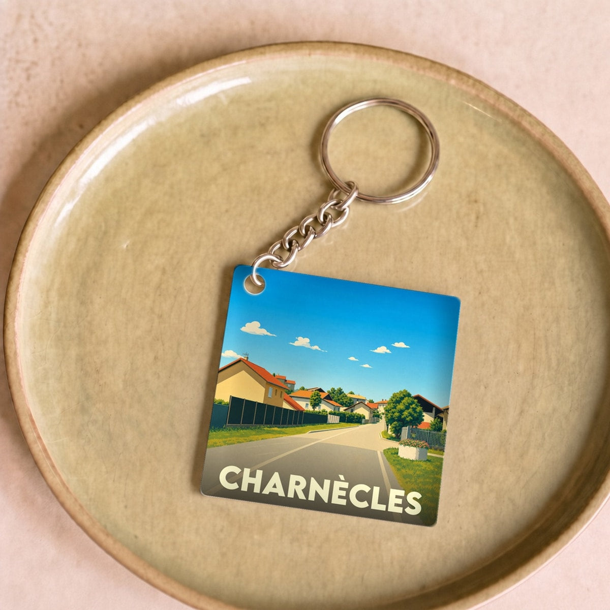 Porte-clés souvenir de la ville de Charnècles avec une illustration stylisée.