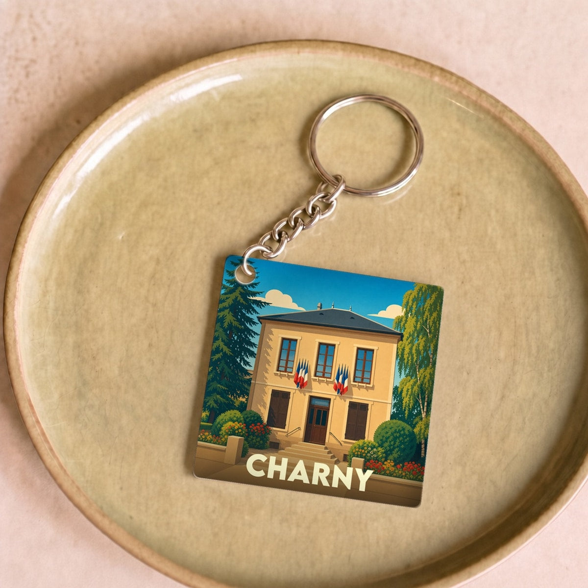 Porte-clés souvenir de la ville de Charny avec une illustration stylisée de sa mairie.