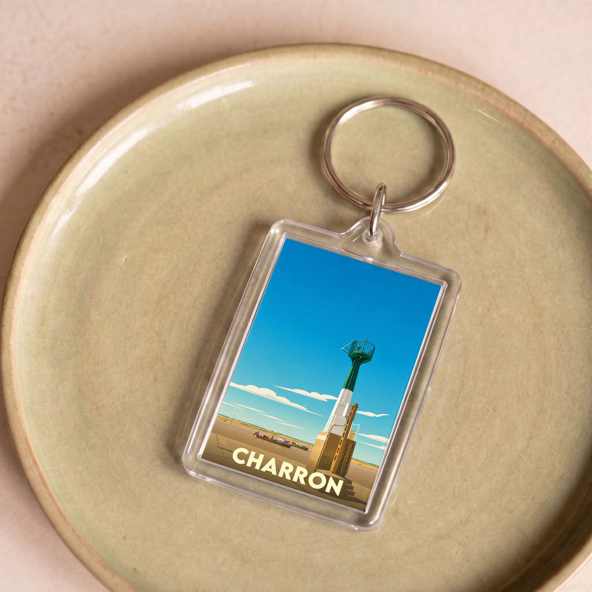 Porte-clés souvenir de la ville de Charron avec une illustration stylisée de son phare.