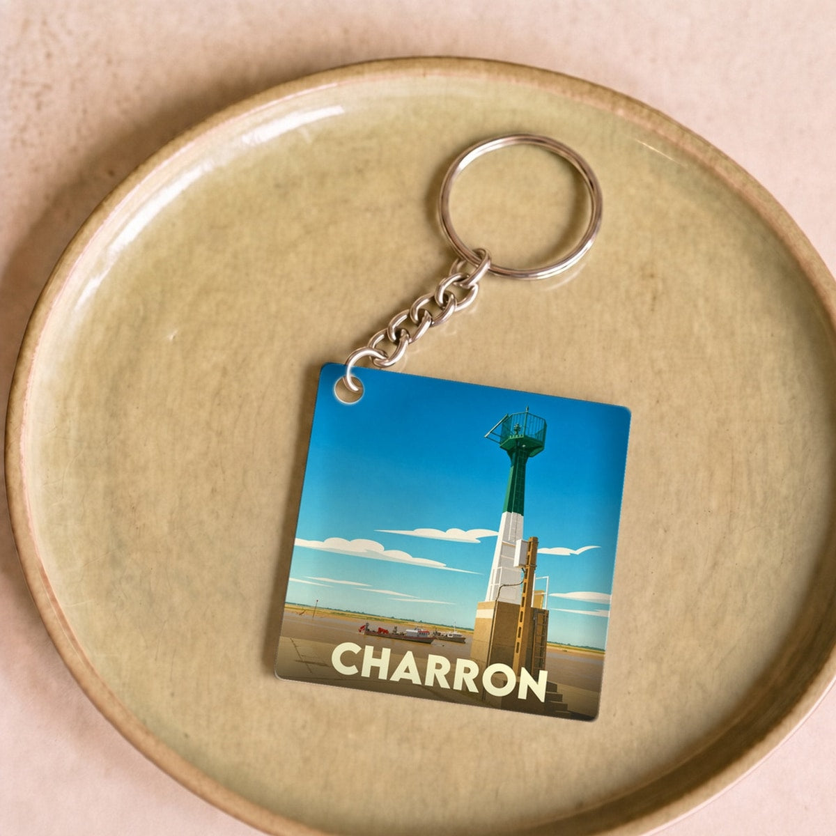 Porte-clés souvenir de la ville de Charron avec une illustration stylisée de son phare.