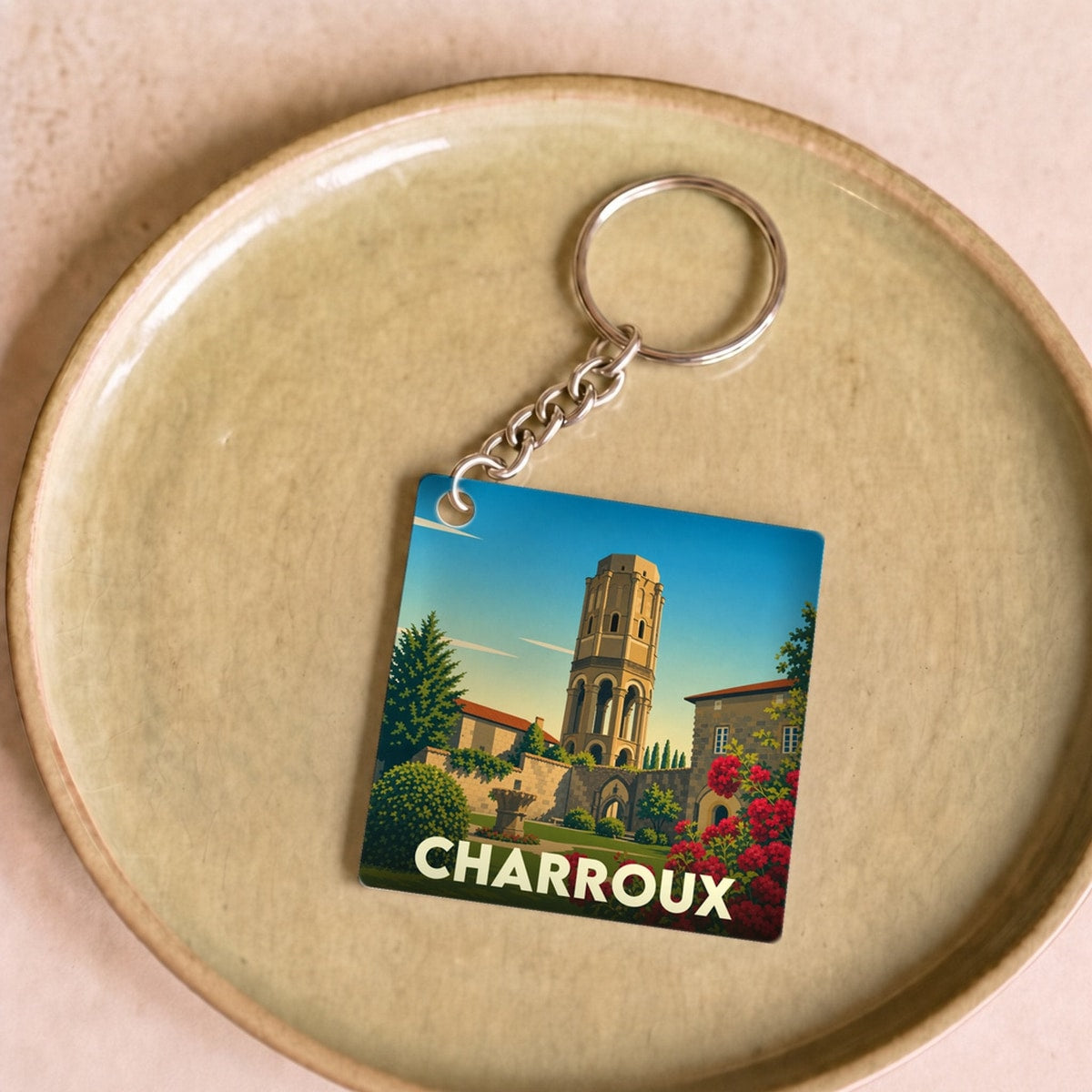 Porte-clés souvenir de la ville de Charroux avec une illustration stylisée de sa tour médiévale.