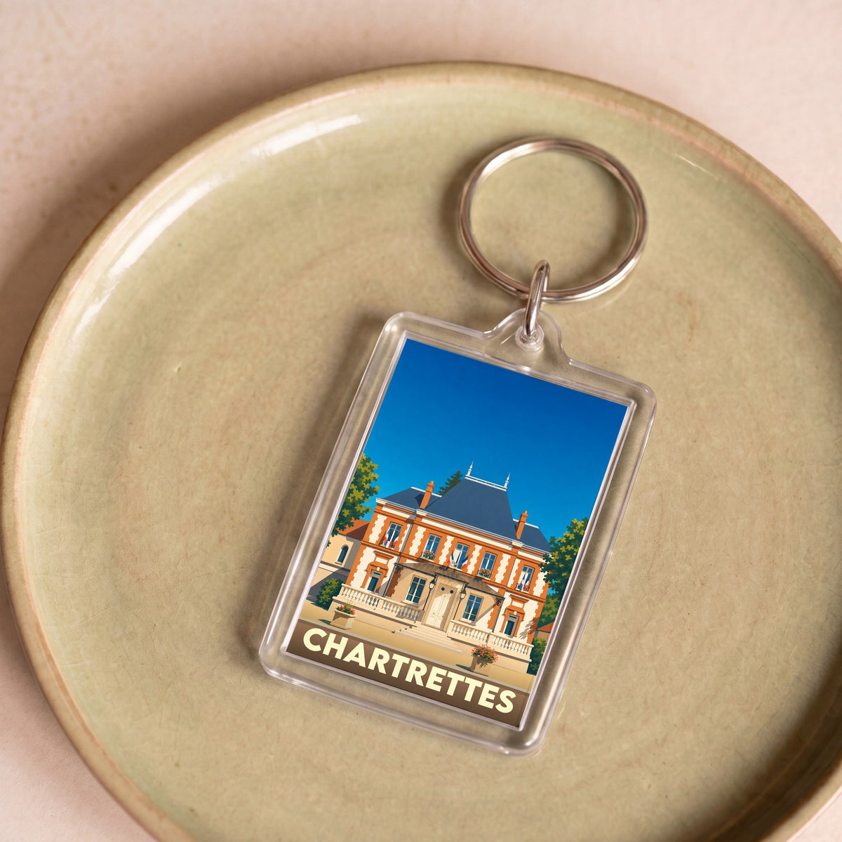 Porte-clés souvenir de la ville de Chartrettes avec une illustration stylisée de la mairie.