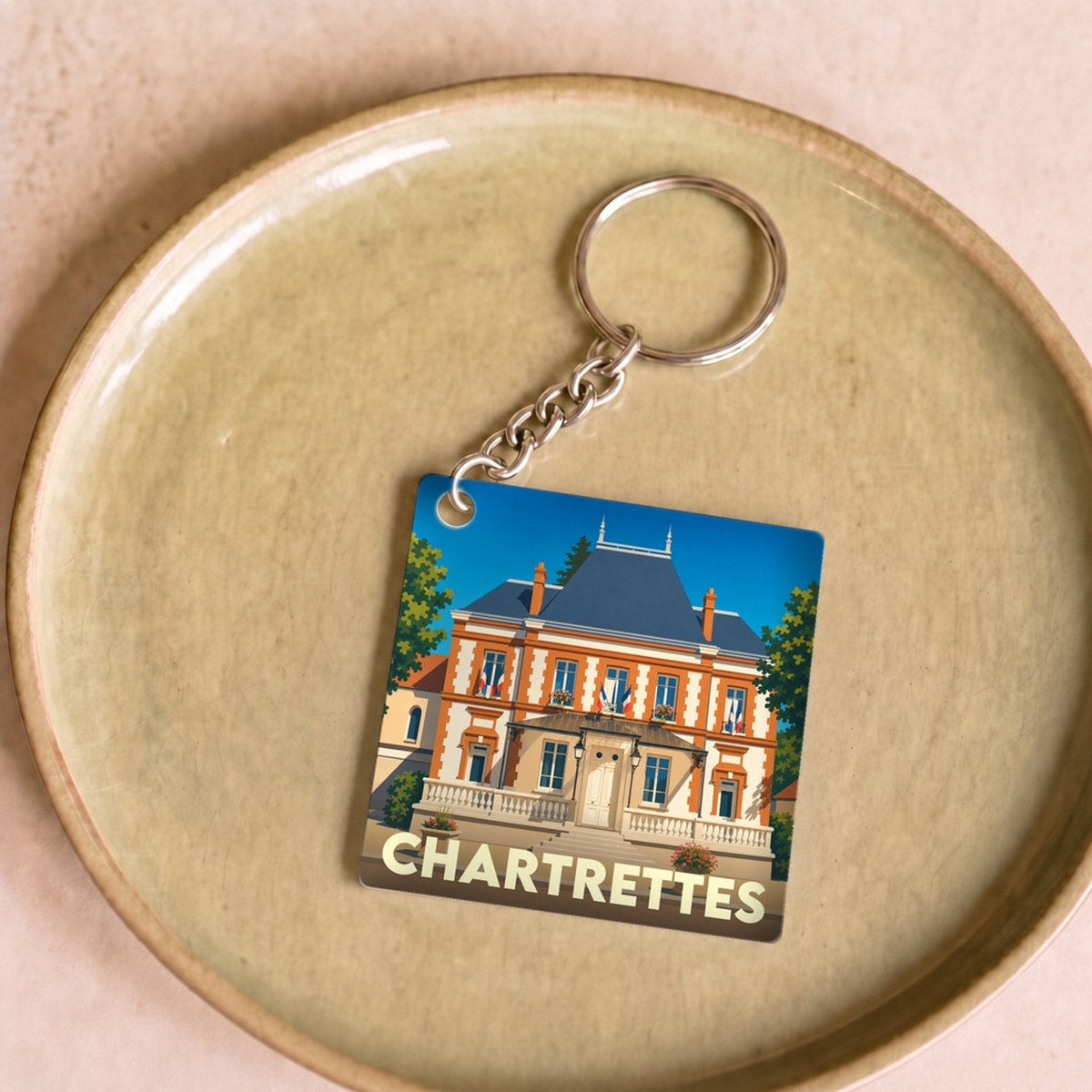 Porte-clés souvenir de la ville de Chartrettes avec une illustration stylisée de la mairie.