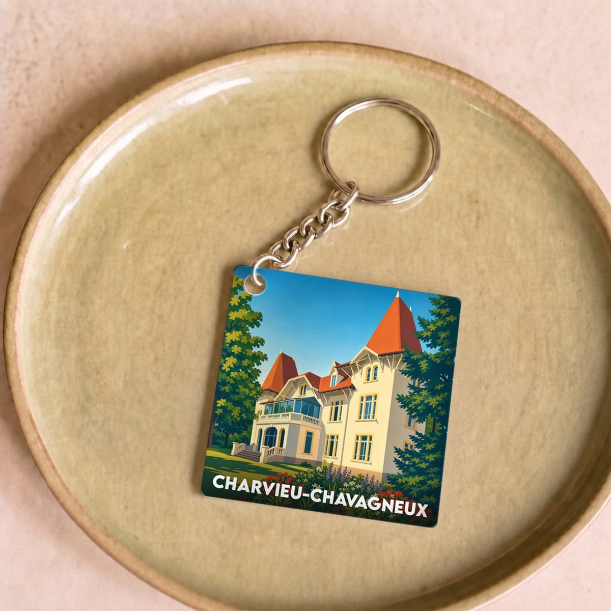 Porte-clés souvenir de la ville de Charvieu-Chavagneux avec une illustration stylisée d'un manoir.