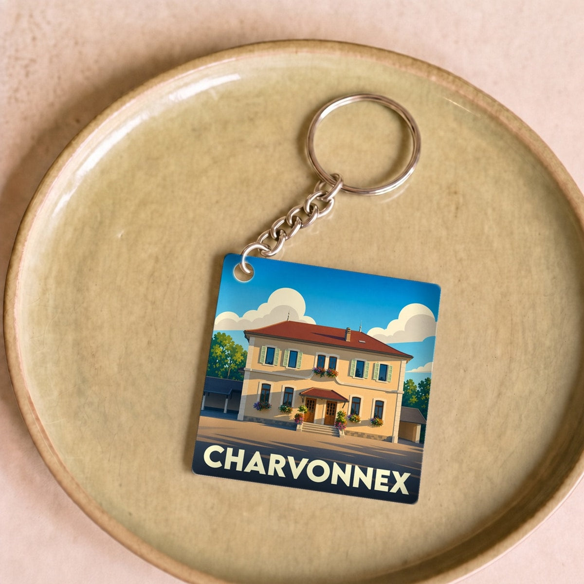 Porte-clés souvenir de la ville de Charvonnex avec une illustration stylisée.