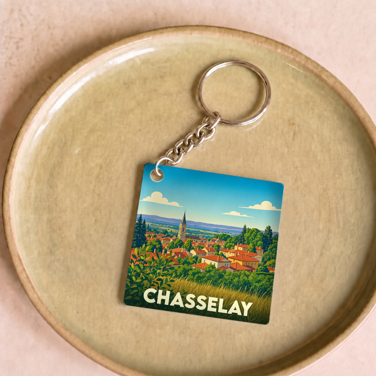 Porte-clés souvenir de la ville de Chasselay avec une illustration stylisée.