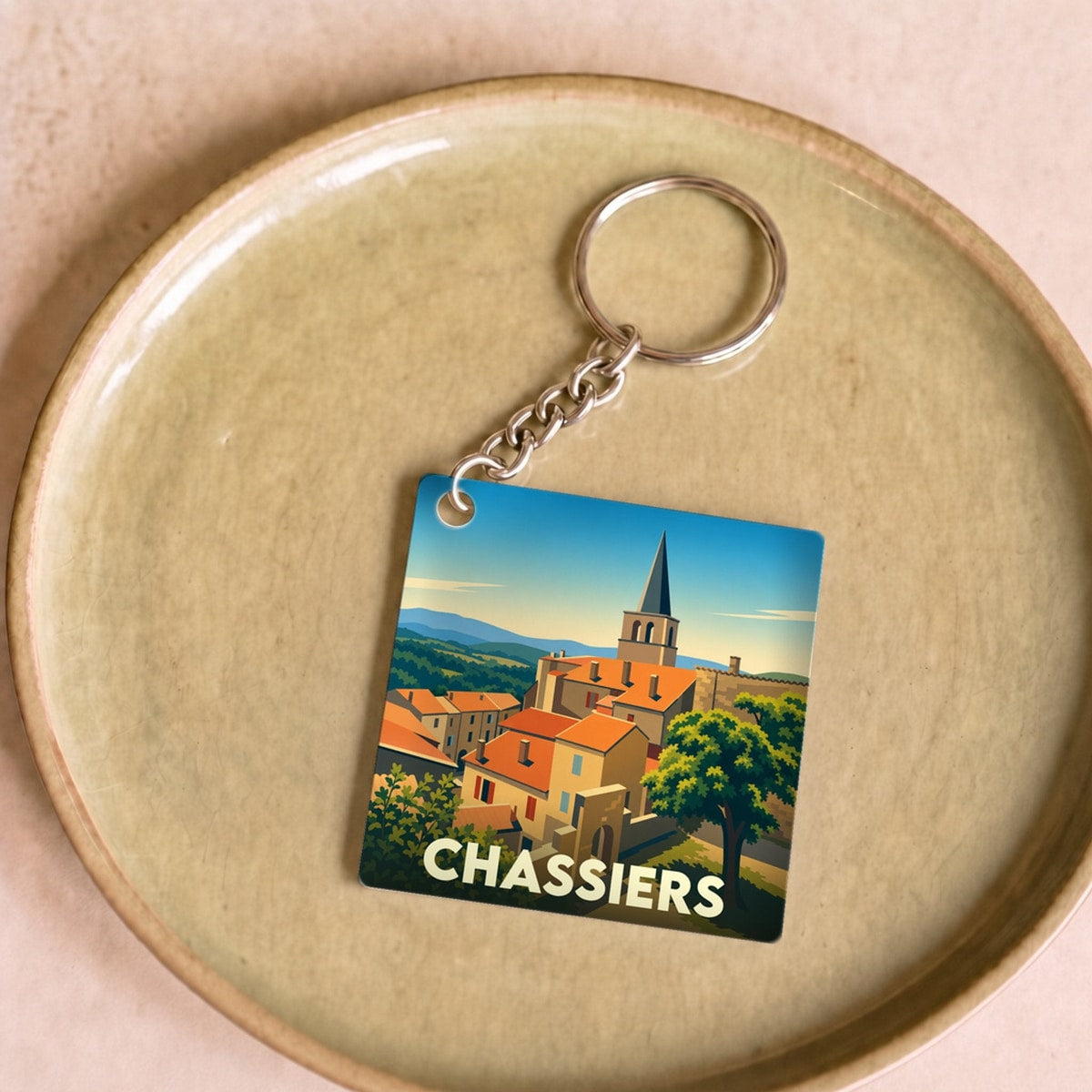 Porte-clés souvenir de la ville de Chassiers avec une illustration stylisée.